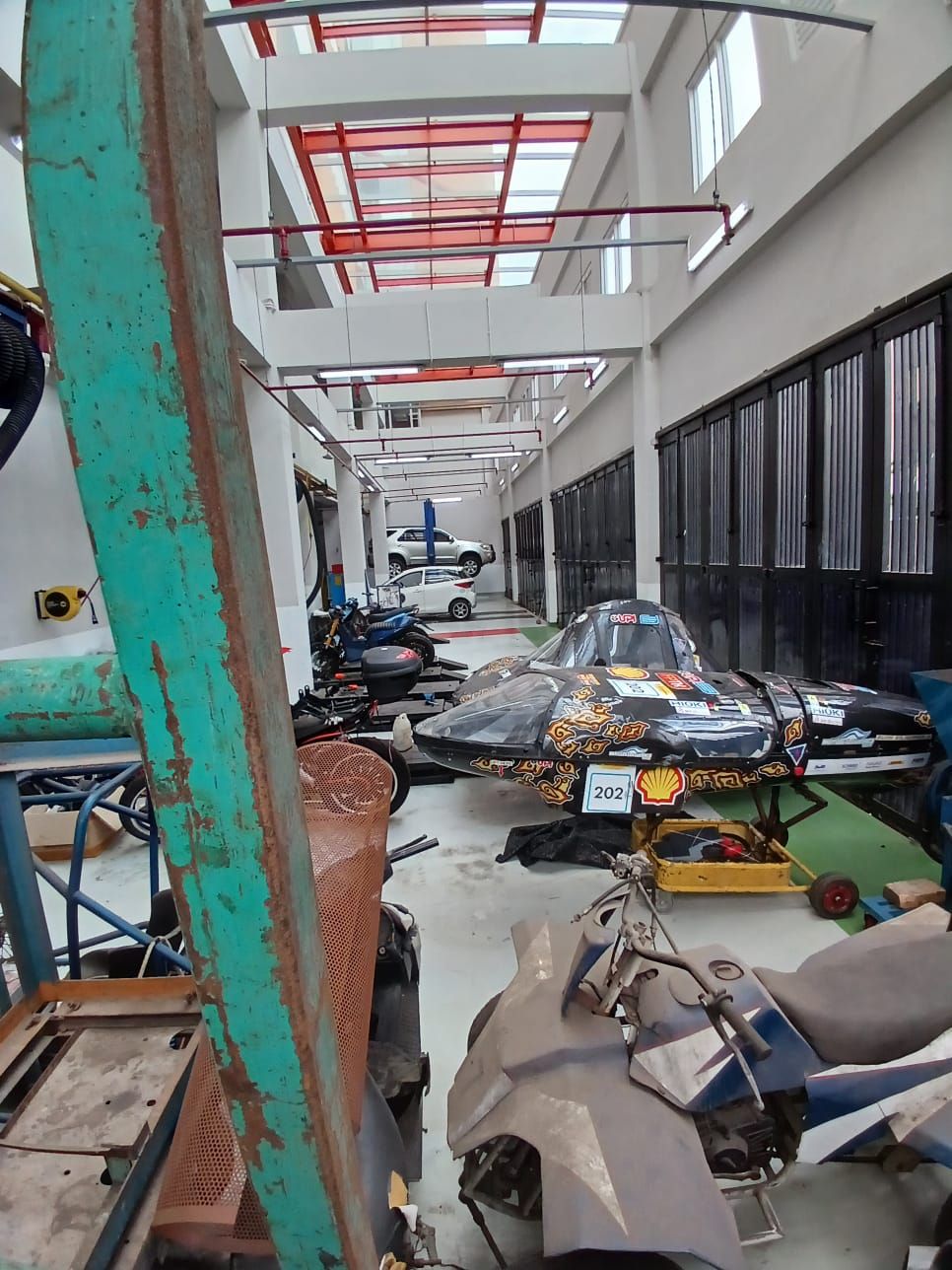 UPI automotive hall with vehicle lifts, an energy-efficient race car and electric motorcycles